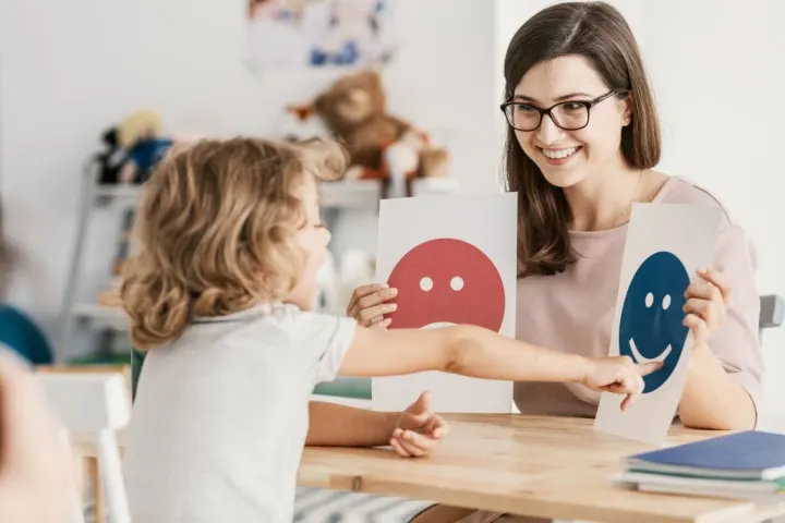 A Peel Autism Services behaviour therapist working one-on-one with a smiling child during an ABA session